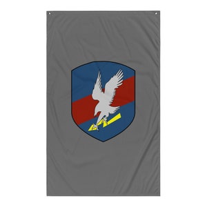 May include: A gray flag with a blue, red, and yellow shield featuring a white eagle with a lightning bolt.