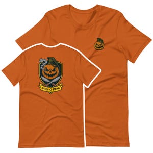 May include: Orange short-sleeved t-shirt with a Halloween graphic. The back graphic shows a jack-o'-lantern with a grenade, knives, and the text "JACK-O-FRAG". A smaller jack-o'-lantern is embroidered on the front of the tee.