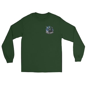 May include: A dark green long-sleeve shirt with a small graphic on the upper left chest. The graphic features a skull with a motorcycle helmet and the words "GHOST RIDER" in a curved font. The shirt is made of a soft material.