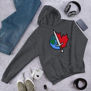 May include: A dark gray hooded sweatshirt featuring a graphic print on the chest. The design displays a split circular emblem with a blue and green globe on the left side and a red maple leaf on the right, bisected by a silver sword with a brown hilt.