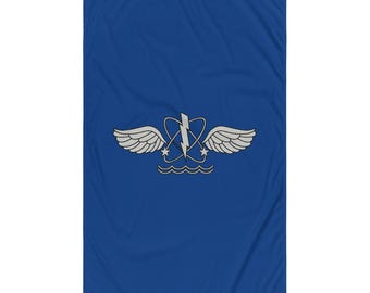 May include: A blue flag featuring a silver emblem with wings, a lightning bolt, and stars above wavy lines. The flag is rectangular and has a grommet at the top for hanging.