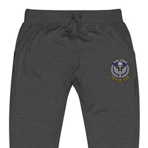 Könnte beinhalten: Dunkelgraue Jogginghose mit Kordelzug und Taschen. Ein kreisförmiger Aufnäher am linken Bein zeigt einen Totenkopf, Flügel und den Text "TASK FORCE PHANTOM TALON" in blau-gelbem Design.