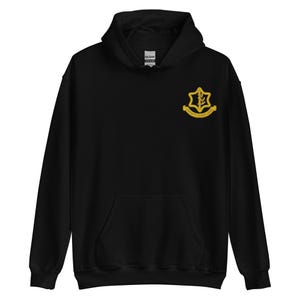 May include: Black hooded sweatshirt with a front pocket and a drawstring hood. The sweatshirt features a gold emblem on the upper left chest. The emblem has a leaf design and text. The sweatshirt is made of a soft material.