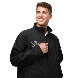 May include: Black softshell jacket with a pirate skull and crossbones logo on the chest. The jacket has a full-length zipper, a stand-up collar, and side pockets. The logo is in a silver color.