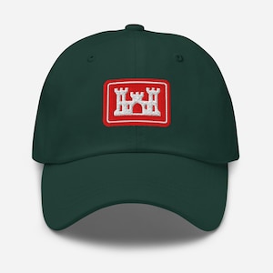 Peut inclure: Casquette de baseball vert foncé avec un écusson brodé blanc et rouge représentant un château. La casquette a une visière incurvée et une sangle réglable à l'arrière.