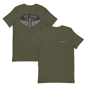 May include: Olive green t-shirts with the text "160th SOAR" and a graphic of a sword and wings. One shirt displays the graphic on the back, and the other on the front. The shirts are made of a soft material.