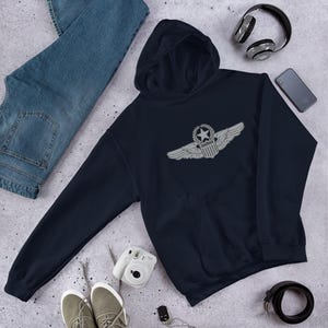 May include: A navy blue hooded sweatshirt with a silver embroidered Aircrew wings patch on the front. The patch features a star, a shield, and wings.