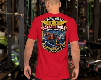 May include: A red short-sleeve t-shirt featuring a graphic on the back with the text United States Coast Guard Rescue Swimmer So That Others May Live, depicting a rescue swimmer, a helicopter, a boat, and gold wings.