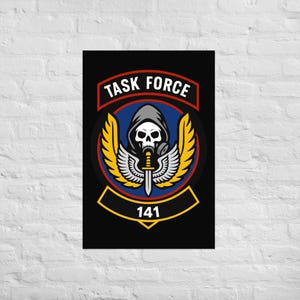 Op de afbeelding: Een zwarte poster met een Task Force-embleem. Het embleem bevat een schedel met een gasmasker, een zwaard en vleugels, met de tekst "TASK FORCE" en "141". Het ontwerp maakt gebruik van rode, gele, blauwe en witte kleuren.