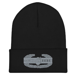 Peut inclure: Béret en tricot noir avec un insigne de fantassin de combat brodé en gris.