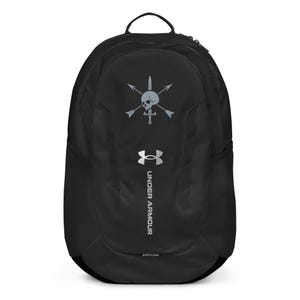 Op de afbeelding: Zwarte Under Armour rugzak met een schedel- en gekruiste bottenlogo, pijlen en het Under Armour-logo in grijs. De rugzak heeft een handvat aan de bovenkant, een zijvak van gaas en een gebogen ontwerp.