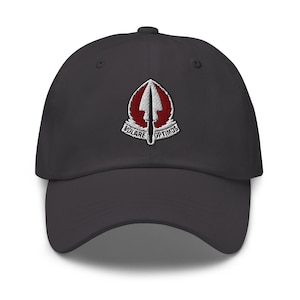 Pode incluir: Boné de beisebol cinza escuro com aba curva. Apresenta um emblema bordado com um design vermelho e branco, com as palavras "VOLARE OPTIMOS". O boné é um estilo clássico e ajustável.