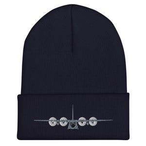 Pode incluir: Um gorro de malha azul marinho com uma imagem bordada em cinza de um avião de carga militar.