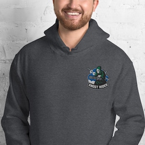 May include: Dark gray hooded sweatshirt with a Ghost Rider patch on the left chest. The patch features a green hooded figure riding a blue motorcycle with the words "Ghost Rider" in white.