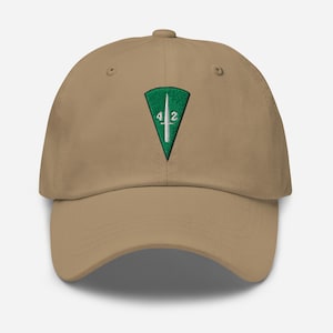 May include: A tan baseball cap with a green and white embroidered emblem. The emblem is a green triangle with the numbers "4" and "2" on either side of a white vertical line. The cap has a curved brim and a fabric strap closure.