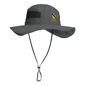 May include: Gray sun hat with a wide brim and a black mesh panel. The hat features a yellow and black emblem with crossed swords. It has an adjustable chin strap for a secure fit. This hat is designed for sun protection.