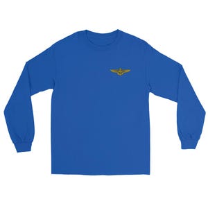 May include: Royal blue long-sleeve shirt with a gold-colored emblem on the chest. The emblem features a winged design. The shirt is made of a soft material.
