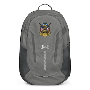 May include: Gray Under Armour backpack with a black mesh side pocket. The backpack features a patch with a snake and the text "Don't Tread on Me." The Under Armour logo is visible.