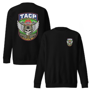 May include: Black sweatshirt featuring a colorful graphic on the back with the text "TACP" and a skull wearing a helmet with wings. The front of the sweatshirt has a smaller version of the graphic.