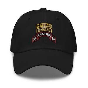 May include: Black baseball cap with embroidered text. The text includes "VETERAN RANGER" in yellow and "RANGER" with "3D BN" in red. The cap has a curved brim and a structured fit.