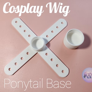 May include: White cosplay wig ponytail base with the text "Cosplay Wig" and "Ponytail Base". The base is made of white plastic and includes a cross-shaped piece with holes and two white cylindrical pieces. The background is a light pink color.