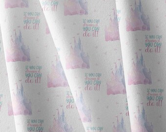 May include: A white fabric featuring a repeating pattern of watercolor-style pink and blue castles. Each castle is accompanied by the text "If you can dream it you can do it!" printed in a mix of blue and pink script and block lettering.