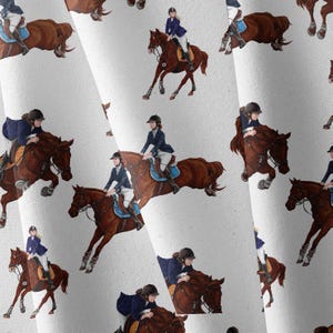 Peut inclure: Un tissu blanc avec un motif répétitif de cavaliers en vestes et casques bleu marine sautant des obstacles sur des chevaux bruns. Les cavaliers sont représentés dans diverses positions, notamment en plein saut et au galop, avec des selles et des brides détaillées.