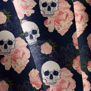 May include: Dark navy fabric featuring a repeating pattern of white skulls and pink peony flowers. The design includes detailed line drawings of the flowers and a textured background, creating a gothic floral aesthetic.