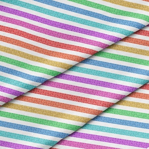 May include: A close-up of a fabric with rainbow colored stripes. The fabric is made of a soft, textured material and has a subtle glitter finish.