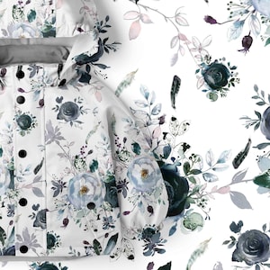 Peut inclure: Une veste à capuche blanche ornée d'un motif floral composé de roses, de feuilles et de brindilles dans des tons bleu marine foncé, bleu clair et vert sourd. La veste présente une patte de boutonnage avec des boutons noirs circulaires.
