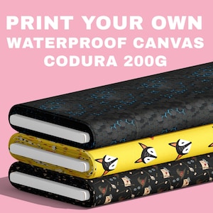 Może przedstawiać: Trzy rolki wodoodpornej tkaniny typu canvas z napisem Codura 200g. Górna rolka jest czarna w niebieski wzór plastra miodu. Środkowa rolka jest żółta w powtarzający się nadruk głów lisa. Dolna rolka jest czarna we wzór kapeluszy, listów i okularów.