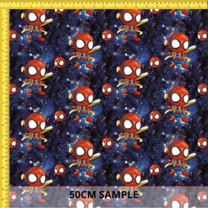Puede incluir: Un estampado de tela con un patrón repetitivo de personajes de Spider-Man en estilo caricatura sobre un fondo de galaxia estrellada azul oscuro. El diseño incluye pequeños iconos circulares rojos. Una regla amarilla es visible.