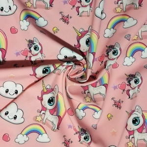 Peut inclure: Un tissu rose clair avec un motif répétitif de licornes blanches à crinière rose et corne dorée, des arcs-en-ciel colorés, des nuages blancs souriants, des cœurs roses, de petits papillons, des étoiles jaunes et des losanges dispersés.