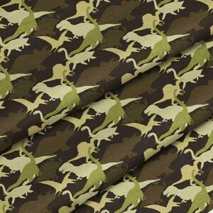 May include: A fabric featuring a repeating pattern of dinosaurs in shades of light green and cream against a dark brown background. The design includes various dinosaur silhouettes arranged in a dense, overlapping layout across the textile surface.