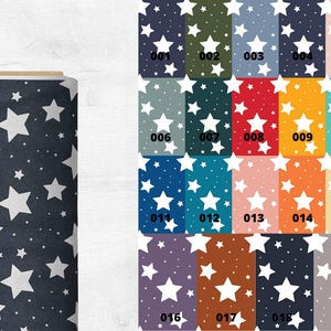 May include: A roll of fabric with a dark blue background and a white star pattern. The image also shows a variety of fabric swatches with different colored backgrounds and white star patterns. Each swatch is labeled with a number.