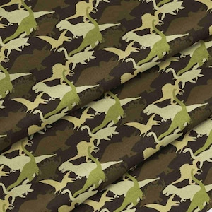 May include: Fabric with a repeating pattern of green and tan dinosaurs on a brown background. The dinosaurs are stylized and appear to be pterodactyls. The fabric has a camouflage-like appearance.