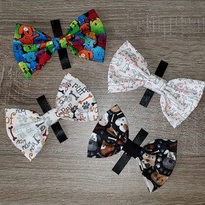 Könnte beinhalten: Vier Hunde-Bowties. Eine ist schwarz-weiß mit Pfotenabdrücken und Knochen, eine ist weiß mit schwarzen Hundesilhouetten, eine ist weiß mit rotem und schwarzem Text, der "Woof of the house" sagt, und eine ist mehrfarbig mit Cartoon-Hunden.