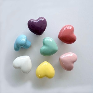 May include: Seven heart-shaped ceramic drawer pulls in various pastel colors, including purple, pink, yellow, blue, and green.