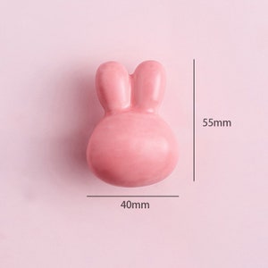 May include: A pink ceramic bunny-shaped door knob with a 40mm width and 55mm height.