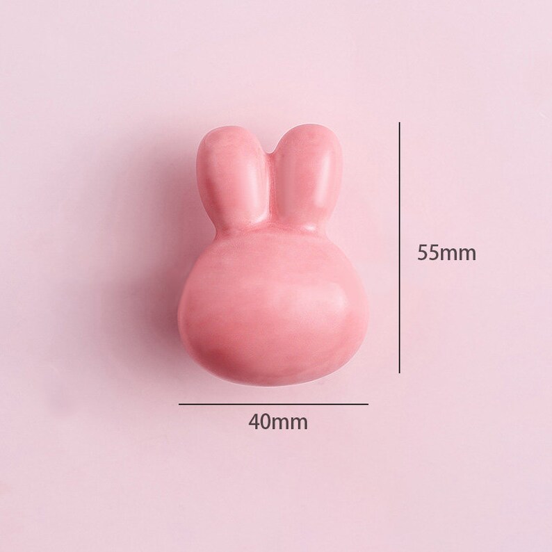 May include: A pink ceramic bunny-shaped door knob with a 40mm width and 55mm height.