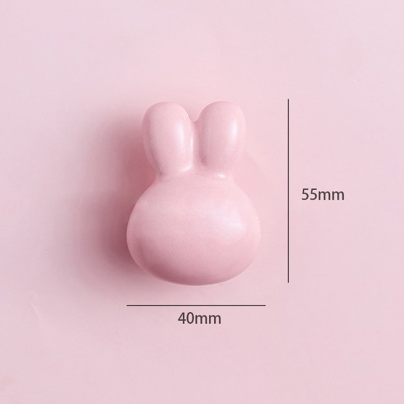 May include: A pink ceramic bunny-shaped drawer pull measuring 40mm wide and 55mm tall.