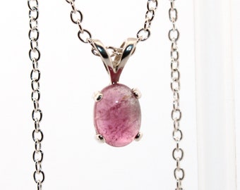 May include: A silver chain necklace with a pink and white oval gemstone pendant.