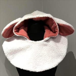 May include: White fleece hooded neck warmer with pink fleece lining and attached ears.
