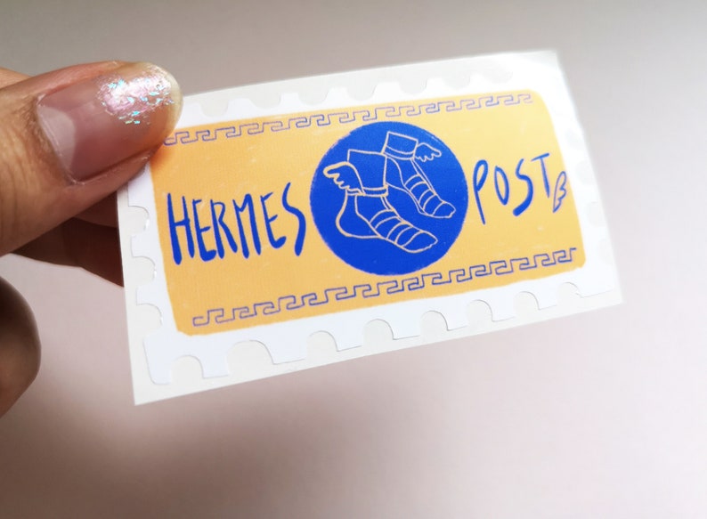 May include: A white sticker with a yellow background and a blue circle. The circle contains a drawing of a winged sandal. The text "HERMES POST" is written in blue on the yellow background.