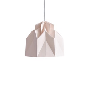 May include: An off-white geometric pendant light with a textured finish. The light, suspended by a white cord, has a layered, origami-style design. This modern light fixture is a decorative element, suitable for various interior settings.