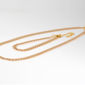 Op de afbeelding: Een gouden ketting met een delicaat, gelaagd ontwerp. De ketting is gemaakt van kleine, puntige schakels die lijken op pijlpunten. De ketting is perfect om te combineren met andere sieraden.