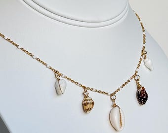 Collar con dije de concha bañado en oro: cauris y caracolas