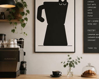 May include: A black and white framed print of a coffee maker with cat ears hangs on a wall. A coffee shop setting includes a coffee machine, a menu board, a cup of coffee, and pastries.