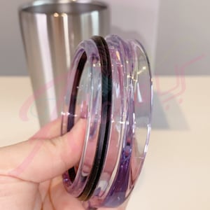 Puede incluir: Una tapa de vidrio transparente con un sello de goma negro. La tapa tiene un tono morado y est&aacute; dise&ntilde;ada para un vaso de acero inoxidable.