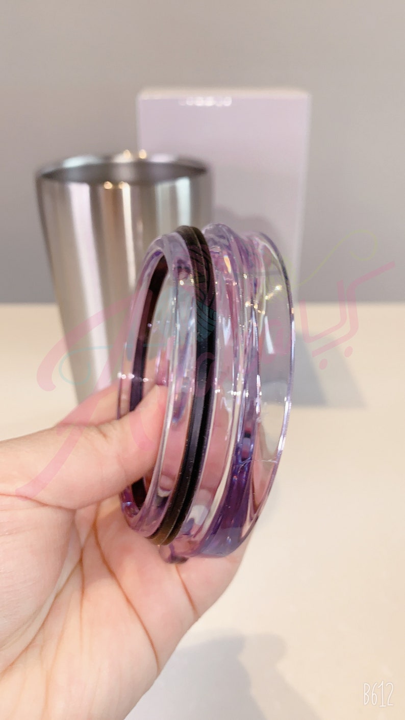 Puede incluir: Una tapa de vidrio transparente con un sello de goma negro. La tapa tiene un tono morado y est&aacute; dise&ntilde;ada para un vaso de acero inoxidable.